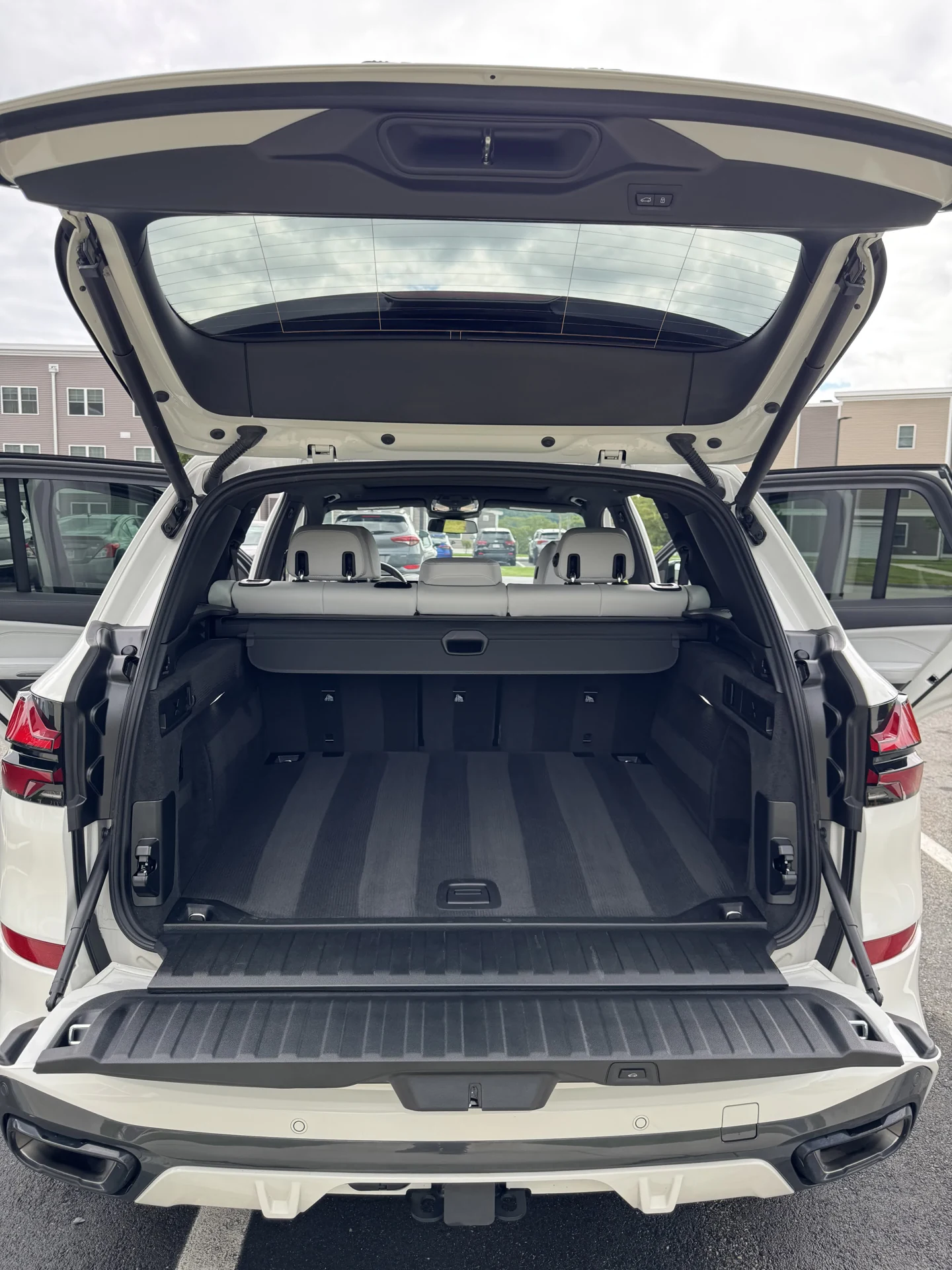 Clean cargo area and cabin of a white SUV, with the tailgate open